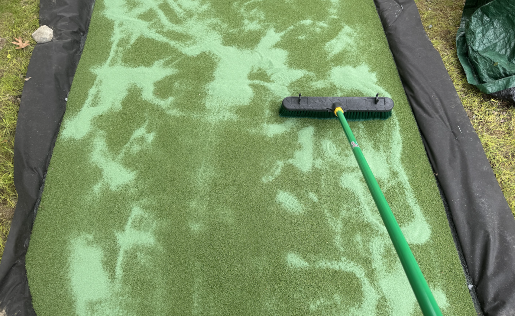 Add Envirofill to the top of your putting green and brush it in